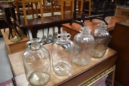 Four traditional glass demijohns