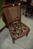 A stained frame bedroom chair having canework back
