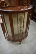 A mid 20th Century walnut bow fronted display cabinet