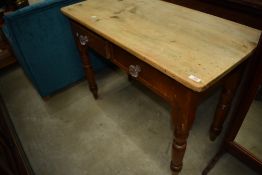 A Victorian pine side table having two frieze drawers with glass handles, on turned legs
