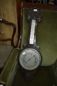 An early 20th Century oak cased aneroid barometer with thermometer scale to stem