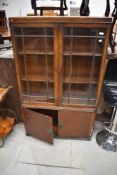 An early 20th Century mahpogany display cabinet having double cupboard to lower section, width