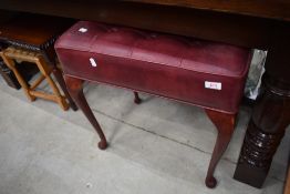 A vintage dressing table stool having buttoned leather top and cabriole legs