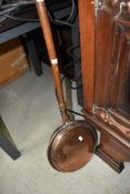 A copper and turned handle bed warming pan