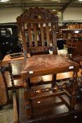 An early 20th Century oak dining chair having carved and slat back and turned rail