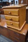 A modern pine three drawer bedside or similar chest