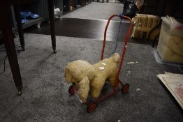 A mid century push along dog toy on wheels.