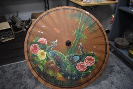 A hand decorated Chinese parasol or umbrella painted with peacocks
