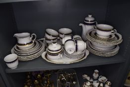 A part tea and dinner service in porcelain by Winterling having blue and gilt design