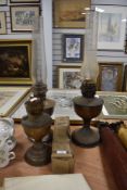 Three oil lamp bases, two with chimneys and a spare chimney in original packaging.