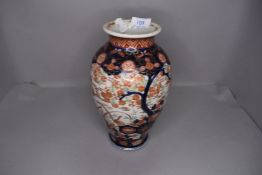 A Chinese hard paste vase hand decorated with landscape in Imari palette