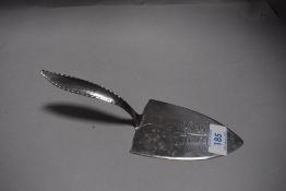 A Keswick school of industrial arts cake slice having hammered handle and leaf motif.