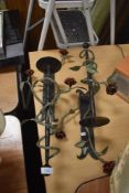 A pair of metal cast wall sconce candle sticks with floral details