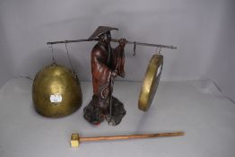A 19th century spelter figure of a China man holding dinner gong and bell