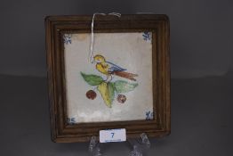 An antique polychrome Dutch delft tile having bird design or fruiting leafs