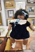 A doll and a small wicker chair.