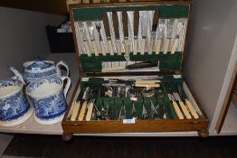 A vintage oak part canteen of cutlery, including bone handled knives and forks.