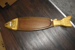 A large fish serving platter in the form of a salmon with golden head and tail