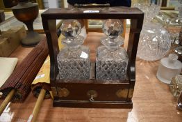 A mahogany Tantalus having two decanters, key present.