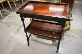 An early 20th Century mahogany tea trolley with fold over top