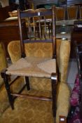 An early 19th century elm spindle back vernacular chair having rush seat