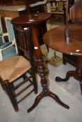 A modern mahogany plant stand having turned frame on tripod base
