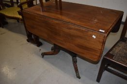 A Regency mahogany table having drop leaves, drawer to one end on quadruple legs with brass feet and