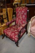 A Victorian mahogany framed upholstered armchair having turned legs