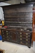 A traditional Welsh style antique dresser base and a later delft plate rack