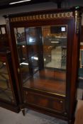 A modern reproduction Empire style display case or cabinet with gilt and ormalu details