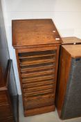A late 19th or early 20th Century oak music cabinet/stand having tambour front