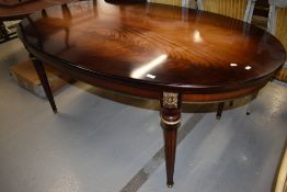 An Empire styled dinning table having quarter panel veneered top with ormalu decoration