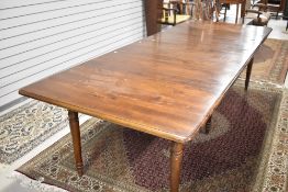 A modern dark stained extending dining table having turned legs and four additional leaves