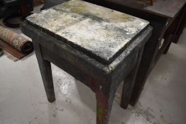 An industrial printers block or similar table having stone top