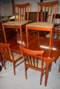 A mid century teak extending dining table and set of four chairs by McIntosh