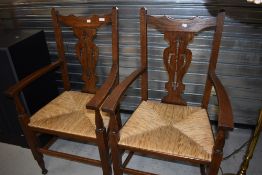 A pair of oak framed arts and crafts styled large carver chairs
