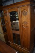 A late Victorian satinwood single wardrobe, having mirror door and drawer under, w 107cm