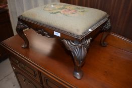 A foot stool having upholstered top and carved cabriole legs