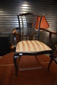 An Edwardian mahogany salon armchair having shaped slat back having striped upholstery and pad feet