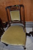 A Victorian nursing chair with mahogany frame and fretted back