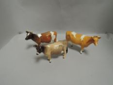 Three Beswick cow studies including Guernsey cow 1248B, Jersey Cow 1345, and Ayrshire Cow 1350