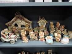 A large collection of Pendelfin bunny rabbit figures including tree stump stands