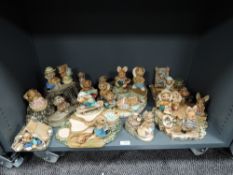 A large collection of Pendelfin bunny rabbit figures including tree stump stands