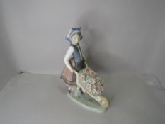 A Lladro Figurine, A Barrow Of Blossoms, girl pushing wheelbarrow full of flowers, model no 1419
