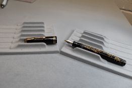 A Parker Vacumatic button fill fountain pen in brown transparent with three narrow bands to the