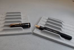 A Parker Moderne button fill fountain pen in black with single band to the cap and having Parker 14K