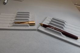 A Parker 65 vacuum converter fill in red with rolled gold cap having Parker 14k nib. Approx 13.3cm