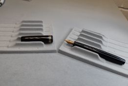A Parker Duofold buttonfill fountain pen in black with two rings to cap having Parker Duofold G nib.