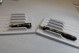 A Parker Deluxe Challenger button fill fountain pen in green, gold and black with three narrow bands