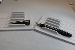 A Parker Vacumatic button fill fountain pen in grey tansparant striated with two narrow bands to the